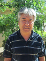 A gray-haired man in a dark collared shirt